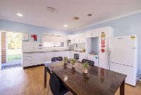 Unit 2s-kitchen-and-dining-drea-with-wooden-table-and-view-of-the-backyard